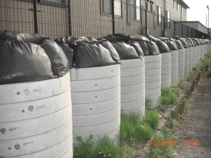 Collected radioactive soil, packed in vinyl bags and then in concrete pipes, are lined up just outside an apartment house in the neighborhood of our Project’s office.