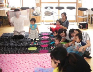 Mothers caressing their babies at the babies’ yoga and massage class. Both are very relaxed.