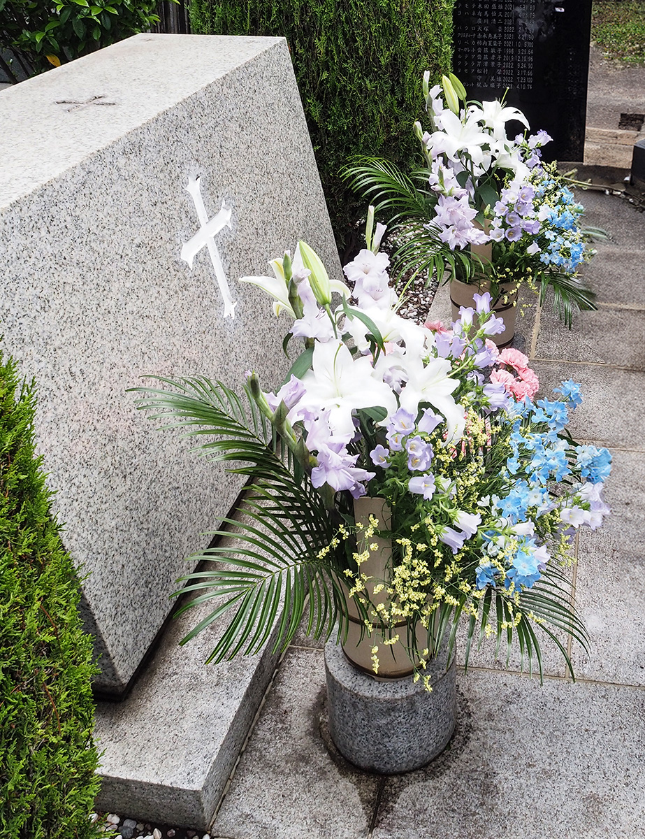 小平霊園の聖マーガレット教会墓地の墓碑の写真。花が飾られている。